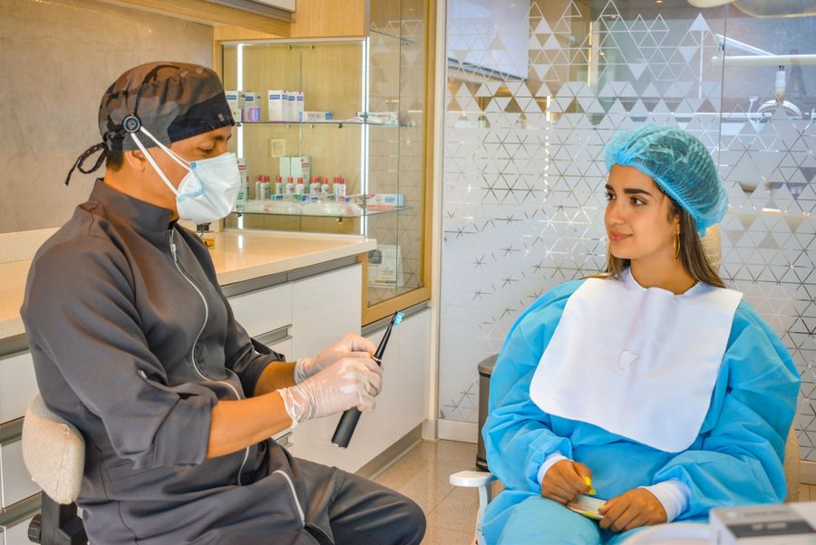 Dentista en consulta con una paciente en la clínica