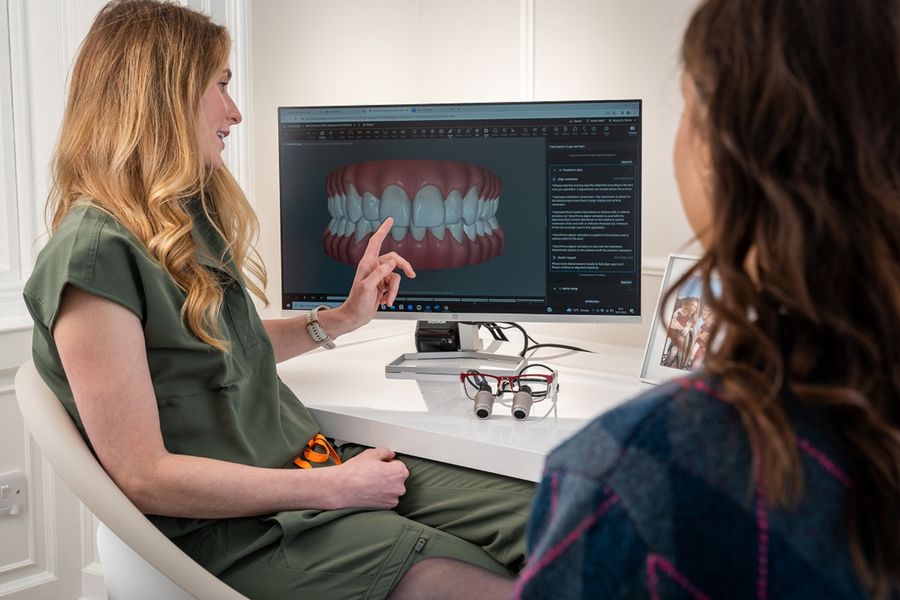Dentista mostrando una imagen dental en pantalla a la paciente